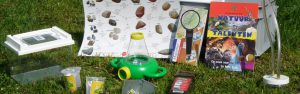 Verschillende onderdelen van een ontdekkist; een kist voor kinderen met een insectenloep, zoekkaarten, etc. om in de natuur op onderzoek uit te gaan.